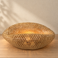 Handwoven bamboo halo lamp shade illuminated in a natural interior